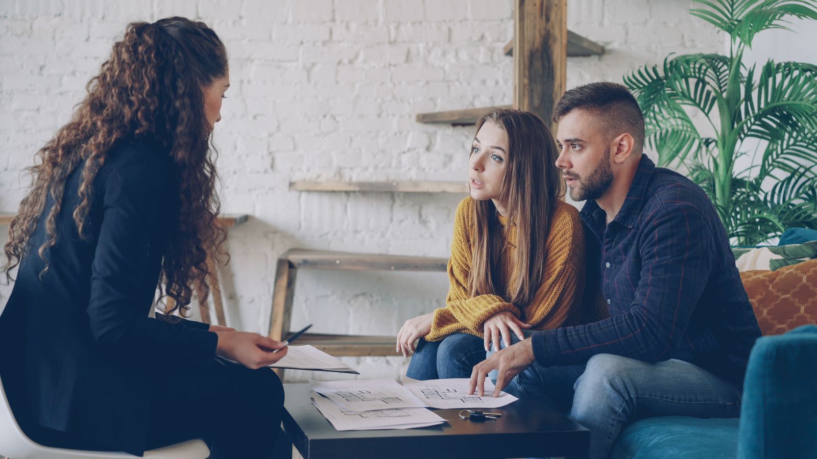 Advisor and clients reviewing documents at a consultation table